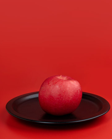 Happy Chinese New Year. Apple, Chinese Gold Sycee, angpao or red packet monetary gift for a symbol of prosperity. Isolated red. Copy space. Usable for wallpaper, greeting card, design.の写真素材