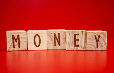 Chinese New Year concept. Money word written on wood block on red background. Isolated red.の写真素材