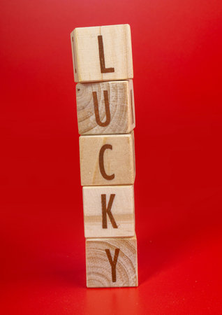 Chinese New Year concept. Luck word written on wood block on red background. Isolated red.の写真素材