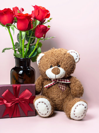 Cute Teddy Bear, gifts and red roses on a pink background. Valentine's concept.の写真素材