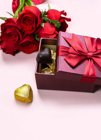 Variety of gifts and chocolates in the shape of a golden heart isolated pink background. Valentine's concept.の写真素材