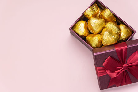 Variety of gifts and chocolates in the shape of a golden heart isolated pink background. Valentine's concept.の写真素材