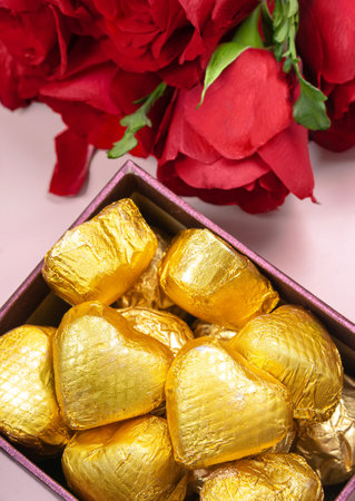 Variety of gifts and chocolates in the shape of a golden heart isolated pink background. Valentine's concept.の写真素材