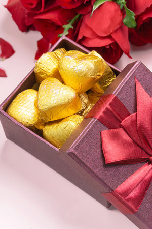 Variety of gifts and chocolates in the shape of a golden heart isolated pink background. Valentine's concept.の写真素材