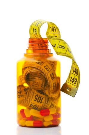 Close up of measuring tape in a pills bottle  Dieting concept の写真素材