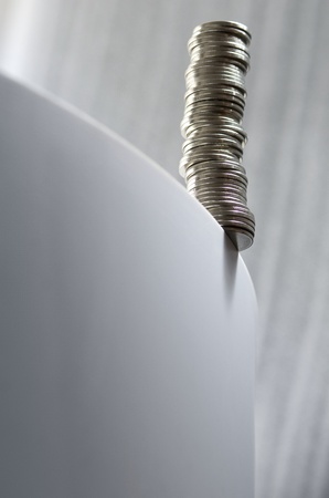 Pile of coins balancing on an edge risking to fallの写真素材