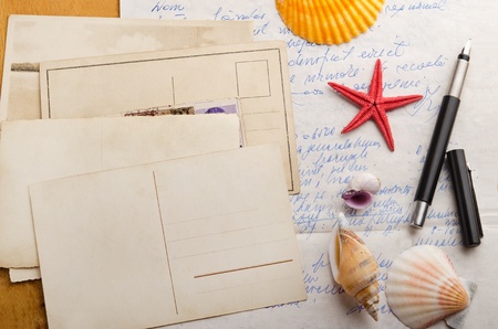 Old postcards and handwritten letter with starfish and shellsの写真素材