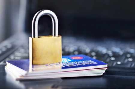Padlock and stack of credit cards on top of laptopの写真素材