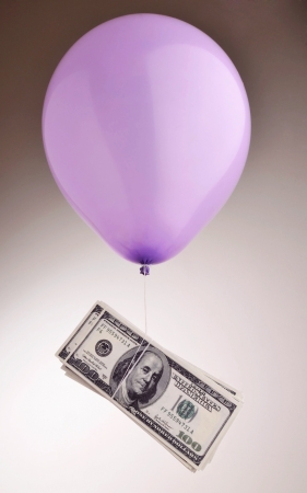 Inflated dollars floating away by balloonの写真素材