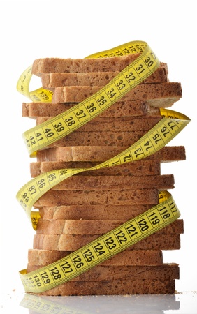 Measuring tape wrapped around stack of slices of breadの写真素材