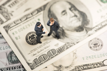 Two businessmen on US paper currencyの写真素材