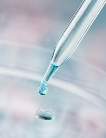 Pipette dispensing a fluid containing a reflection of a DNA sequence gelの写真素材