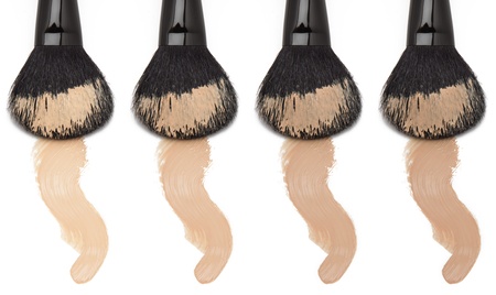 Different tones of foundation with makeup brush on white backgroundの写真素材