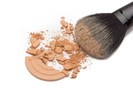 Close-up of crushed cosmetic powder with makeup brush on white backgroundの写真素材
