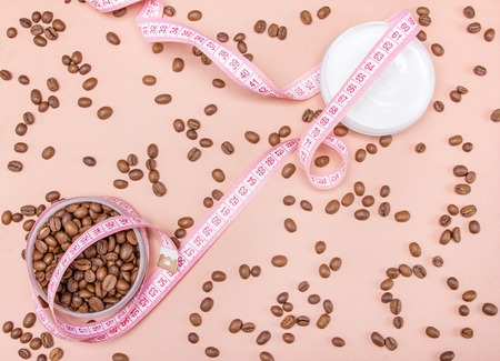 Anti-cellulite cream with caffeine concept  cream, coffee beans and measure tapeの写真素材