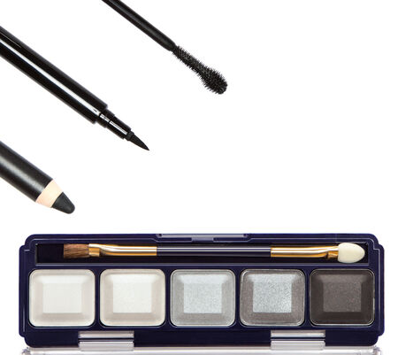 Cosmetic eyeliners, mascara brush, makeup palette with black, gray and bright compact eyeshadow on white backgroundの写真素材