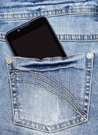 Closeup of mobile smart phone in back pocket of blue jeansの写真素材
