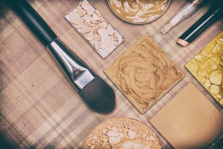 Various makeup products to even out skin tone and complexion on plaid background. Small copy space. Retro style processingの写真素材