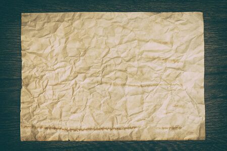 Close-up of old crumpled paper sheet on wooden surface. Retro style processingの写真素材