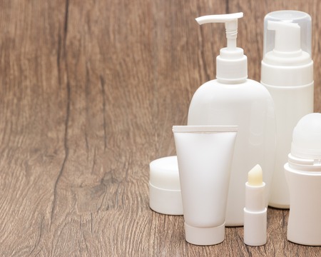 Various cosmetic products for face and body care on wooden surface. Daily skincare cosmetics. Copy...