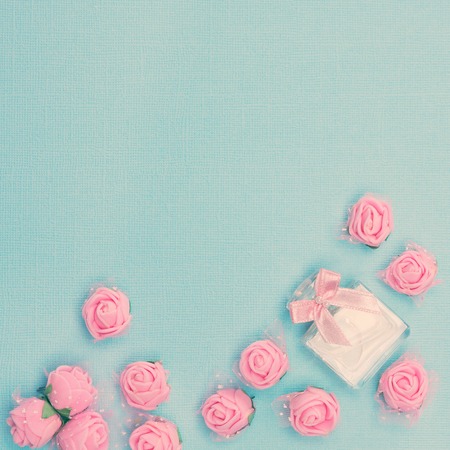 Floral fragrance background. Perfume bottle framed with scattered small roses. Vintage toning, free space for textの写真素材