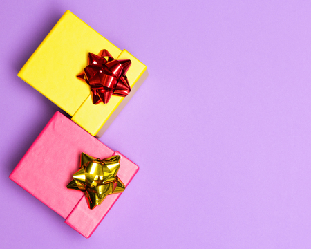 Close-up of two color gift boxes decorated with wrap bows with free space for text. Bright holiday...