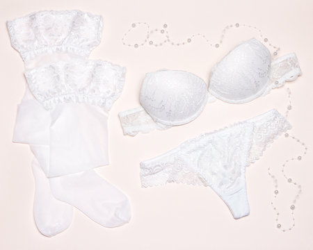 White lingerie set of strapless underwire bra and lace thong pantie with stockings. Accessories of brideの写真素材