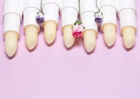 Lip skin care cosmetics products. Lip balms decorated with small paper flowers, copy spaceの写真素材