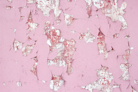 Old shabby wall texture with cracked peeling pink paint. Abstract backgroundの写真素材