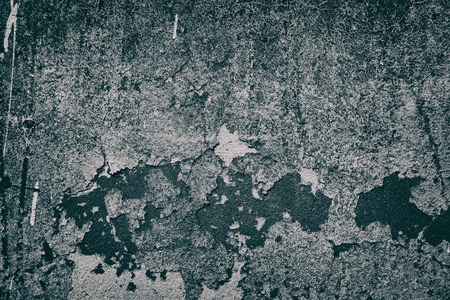 Old shabby concrete wall texture with cracked detached paint. Gloomy gray grunge backgroundの写真素材