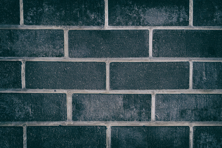 Dark grey close up texture of rough brick tiles. Black brickwork wall backgroundの写真素材