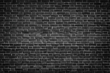 Dark grey brick wall texture. Black masonry background. Rough aged brickworkの写真素材
