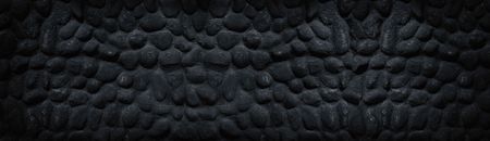 Black stone wall wide panoramic texture. Dark gloomy spacious backgroundの写真素材