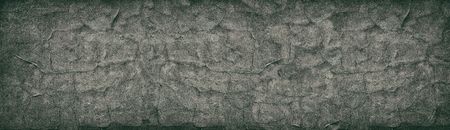 Dark cracked concrete wall wide retro texture. Aged cement surface horizontal panorama. Panoramic...