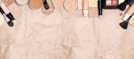 Basic makeup products frame on craft paper. Primer, concealer, foundation, face powder. Make-up widescreen background with empty space for textの写真素材