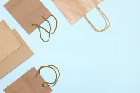 Paper merchandise bags on blue background, flat lay frame with copy space. Shopping, sale minimal conceptの写真素材