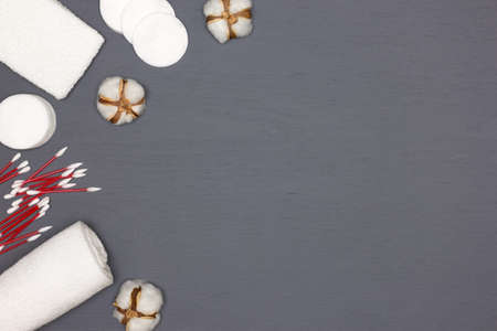 White terry towels, cotton pads and buds with cotton flowers. Top view, flat lay. Copy space. Cotton...