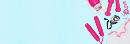 Weight loss cardio workout concept. Jump rope, dumbbells, stopwatch, body weight scale, water bottle, measure tape on blue background. Copy space. Sports and fitness bannerの写真素材