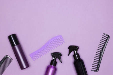 Hair styling products with combs top view on purple background. Copy spaceの写真素材