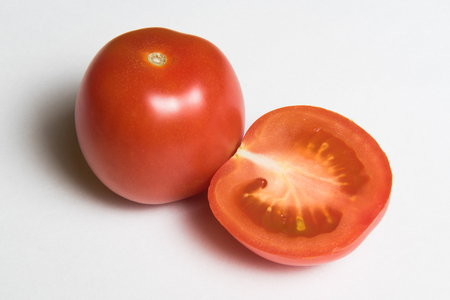 One and half red tomato over white backgroundの写真素材