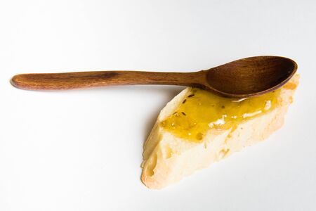 slice of bread with jam and woody spoon isolated on white backgroundの写真素材