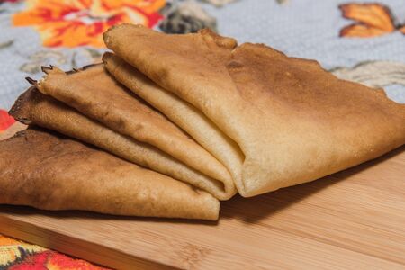 Buttercakes traditional for Russian pancake week on wooden cutting plateの写真素材