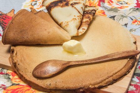 Buttercakes traditional for Russian pancake week on wooden cutting plateの写真素材