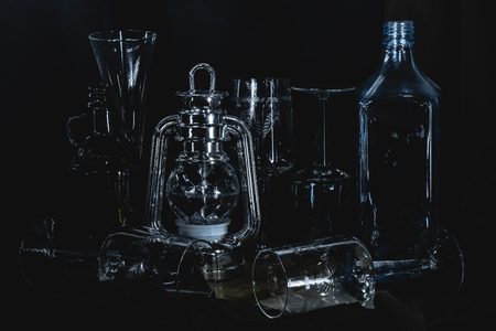 Low-key studio shot of a empty bottles and glasses on a black backgroundの写真素材