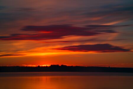 Orange or red sunset at coast of the lake