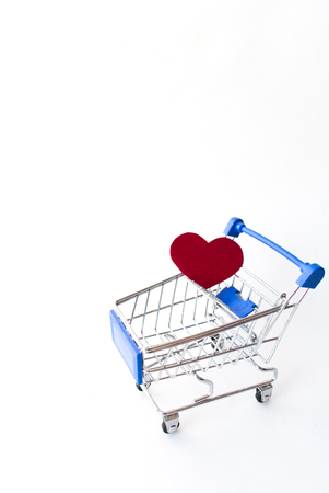 a red heart in a shopping cart on a white backgroundの写真素材
