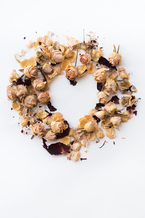 Heart symbol made of flovers and leaves on white background.の写真素材