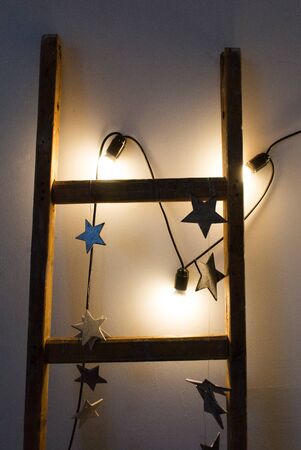 A wooden staircase in an empty room on the background of a concrete wall with hightlights