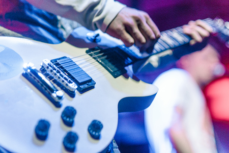 closeup rockstar on stage playing on electro guitar. Male guitaristの写真素材