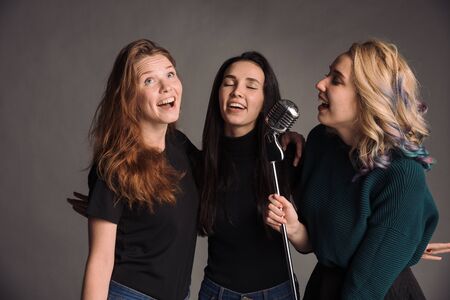 Three young friends standing together. The studio shotの写真素材